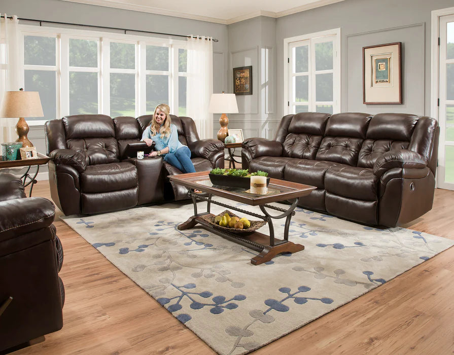 Living room with brown leather recliner sofa set and a woman sitting on one of the chairs.