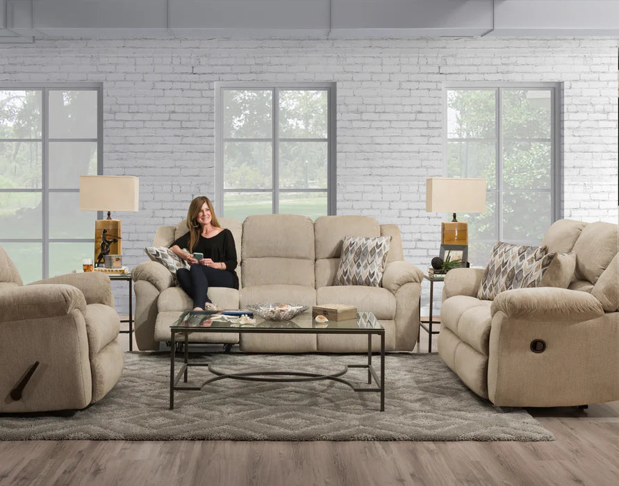 Woman sitting on a beige recliner in a living room with matching furniture.
