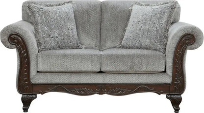 Decorative gray sofa with ornate wooden armrests on a white background